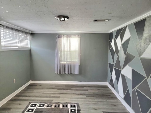 unfurnished room featuring wood-type flooring and a textured ceiling