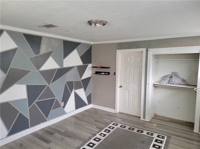 interior space with ornamental molding and hardwood / wood-style floors