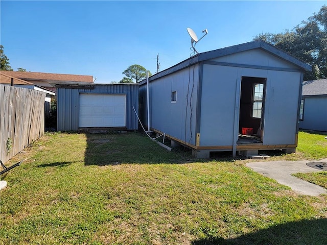 view of outdoor structure featuring a garage and a lawn