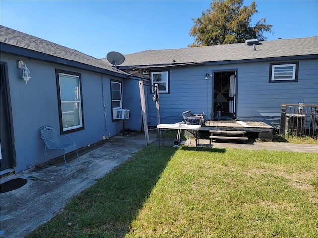 rear view of house with cooling unit, a deck, and a lawn