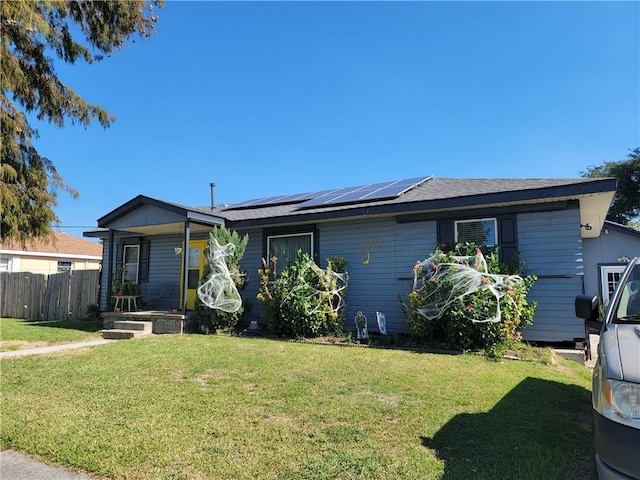 single story home featuring a front yard and solar panels