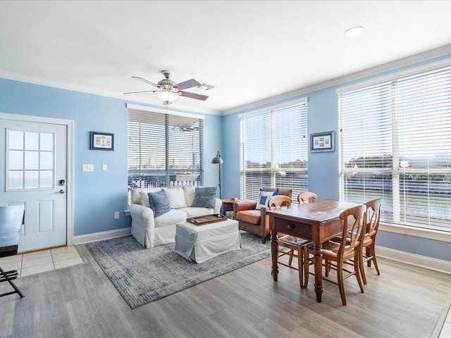 interior space with ornamental molding, light wood-style flooring, baseboards, and a ceiling fan