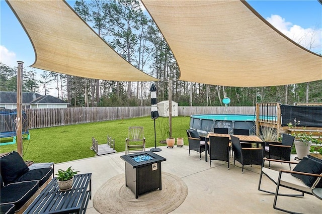 view of patio / terrace featuring a shed, a fenced in pool, and an outdoor fire pit