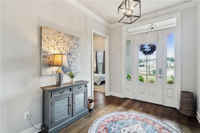 foyer with dark wood-type flooring, ornamental molding, and a chandelier