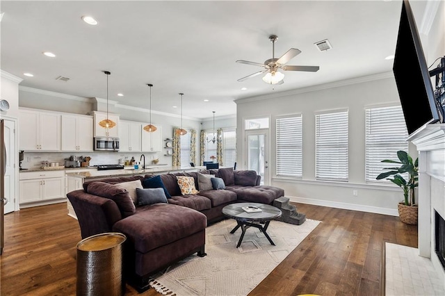 living room featuring a premium fireplace, ornamental molding, and hardwood / wood-style floors