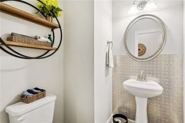 bathroom featuring toilet and a chandelier