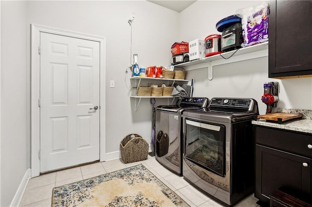 washroom with separate washer and dryer, light tile patterned floors, and cabinets