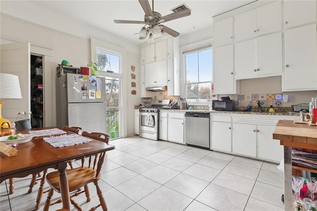 kitchen featuring plenty of natural light, appliances with stainless steel finishes, and white cabinets