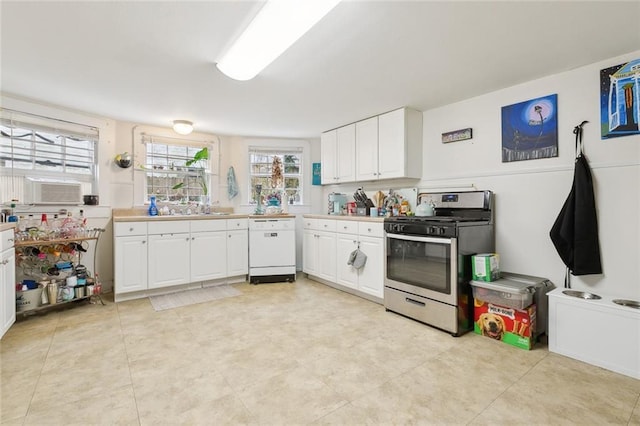 kitchen with white dishwasher, sink, gas range, and white cabinets