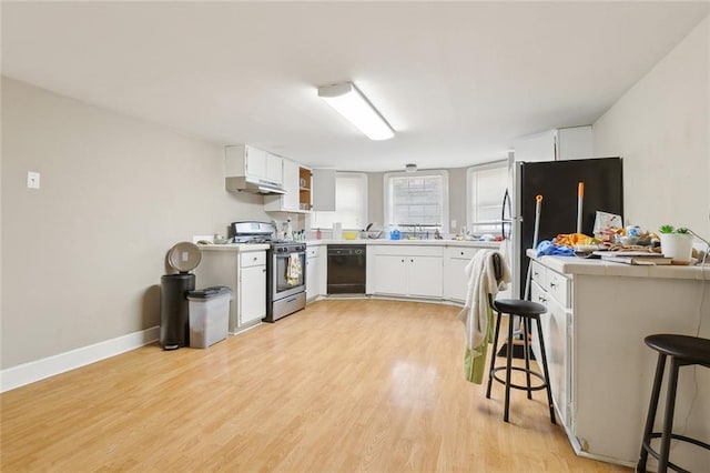 kitchen featuring a breakfast bar, light hardwood / wood-style flooring, stainless steel range with gas stovetop, black dishwasher, and white cabinets