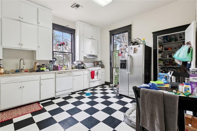 kitchen featuring sink, white cabinets, and white appliances