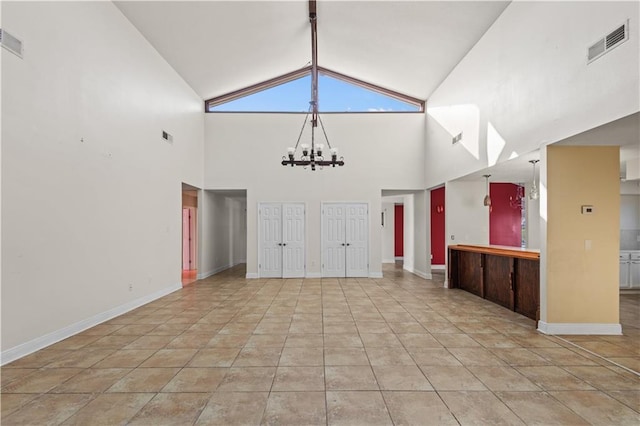 unfurnished living room featuring lofted ceiling, light tile patterned floors, and a notable chandelier