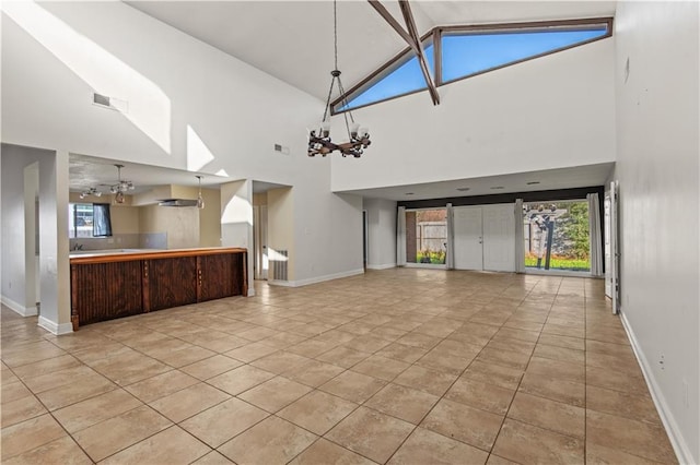 unfurnished living room featuring a notable chandelier, vaulted ceiling with beams, and light tile patterned flooring