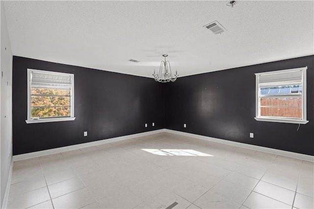 unfurnished room with a chandelier