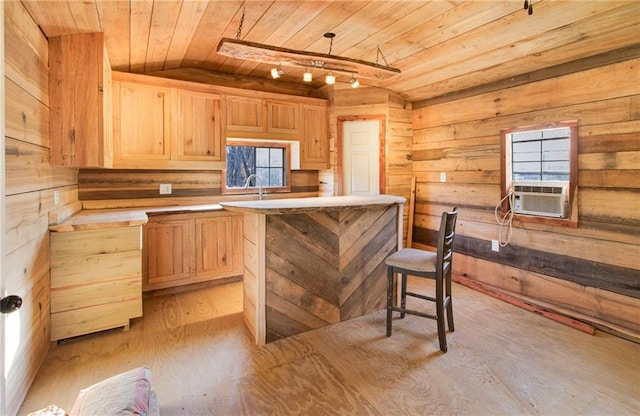 kitchen featuring pendant lighting, a center island, light brown cabinets, wooden ceiling, and wood walls