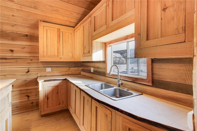 kitchen with light hardwood / wood-style flooring, sink, wooden walls, and wooden ceiling