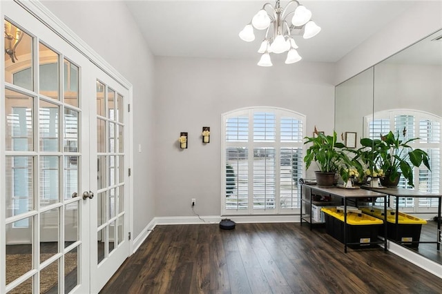 interior space featuring dark hardwood / wood-style floors, an inviting chandelier, and french doors