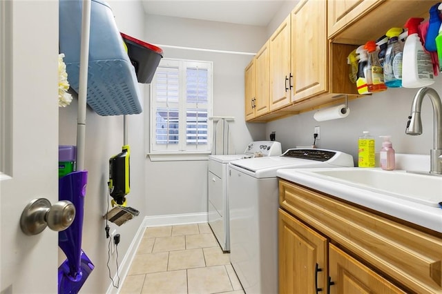 laundry area with light tile patterned floors, washer and clothes dryer, and cabinets