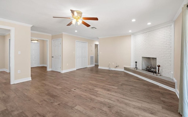 unfurnished living room featuring hardwood / wood-style flooring, ceiling fan, ornamental molding, and a fireplace