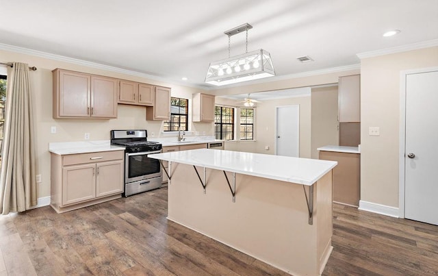 kitchen with dark wood-type flooring, ornamental molding, decorative light fixtures, and gas stove