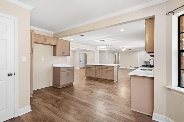 kitchen with pendant lighting, sink, hardwood / wood-style flooring, crown molding, and light brown cabinets