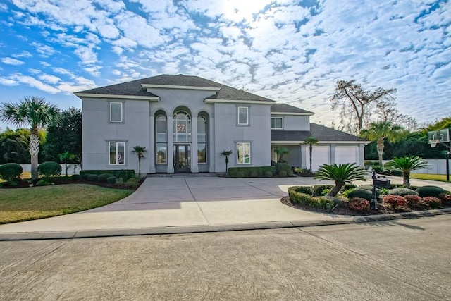 mediterranean / spanish-style home with a garage and a front lawn