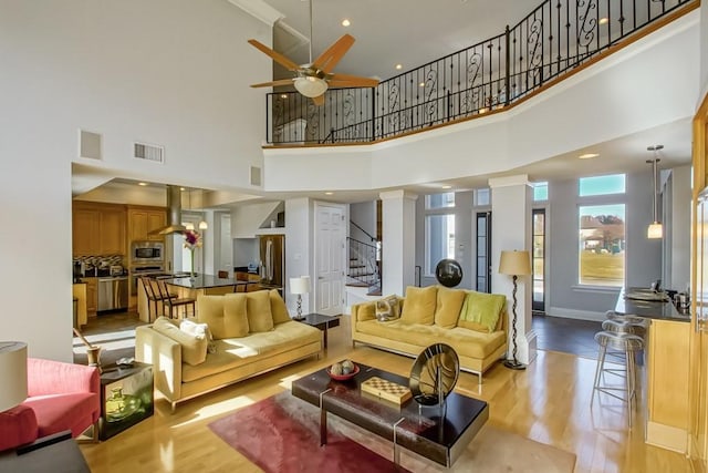 living room with ceiling fan and light hardwood / wood-style flooring