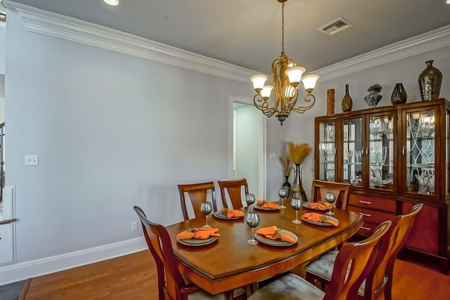 dining space with ornamental molding, dark hardwood / wood-style floors, and a chandelier