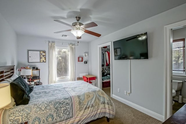 bedroom featuring dark carpet, a closet, ceiling fan, and a spacious closet