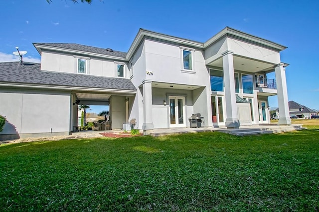 rear view of property featuring a balcony and a lawn