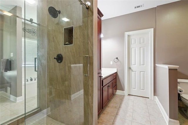 bathroom with vanity, a shower stall, toilet, and tile patterned floors