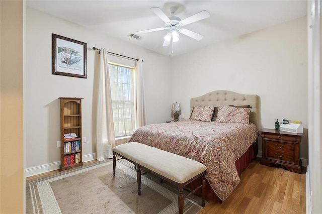 bedroom featuring a ceiling fan, light wood-type flooring, visible vents, and baseboards