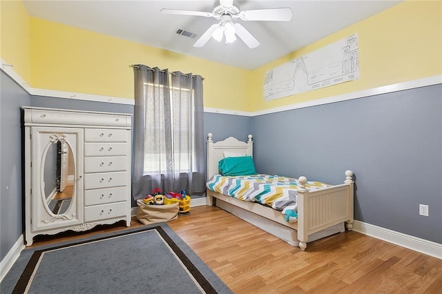 bedroom with visible vents, ceiling fan, baseboards, and wood finished floors