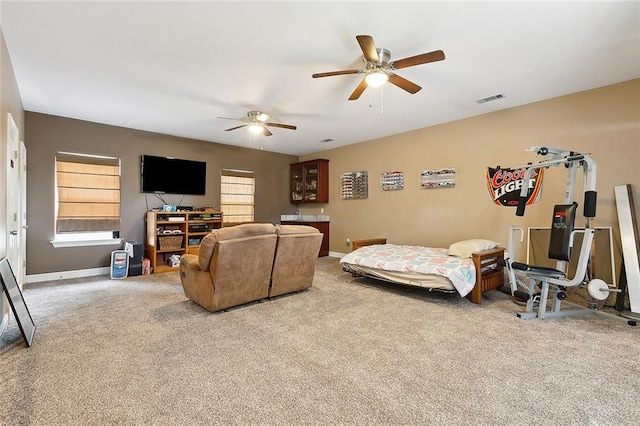 living area with carpet floors, visible vents, baseboards, and a ceiling fan