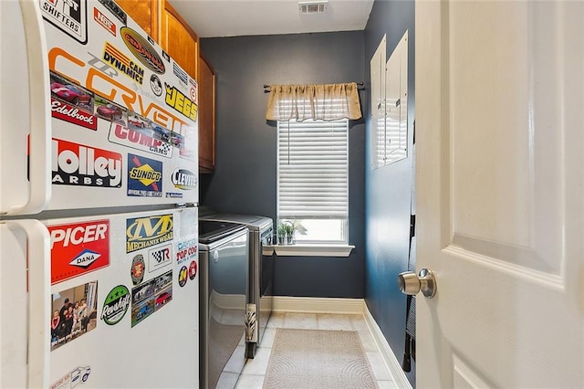 laundry room featuring light tile patterned flooring, washing machine and dryer, visible vents, and baseboards