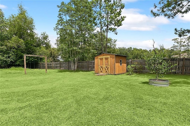 view of yard featuring an outbuilding, a fenced backyard, and a storage unit