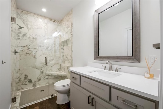 bathroom featuring walk in shower, vanity, toilet, and wood-type flooring