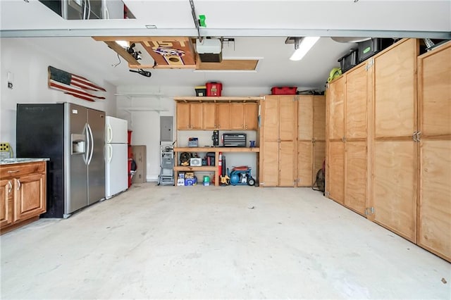 garage featuring white refrigerator, a garage door opener, and stainless steel fridge with ice dispenser