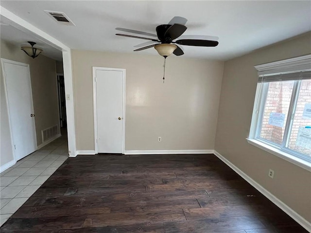 unfurnished room featuring dark wood-type flooring and ceiling fan