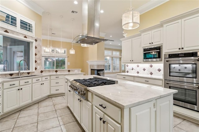 kitchen with stainless steel appliances, island exhaust hood, ornamental molding, and pendant lighting