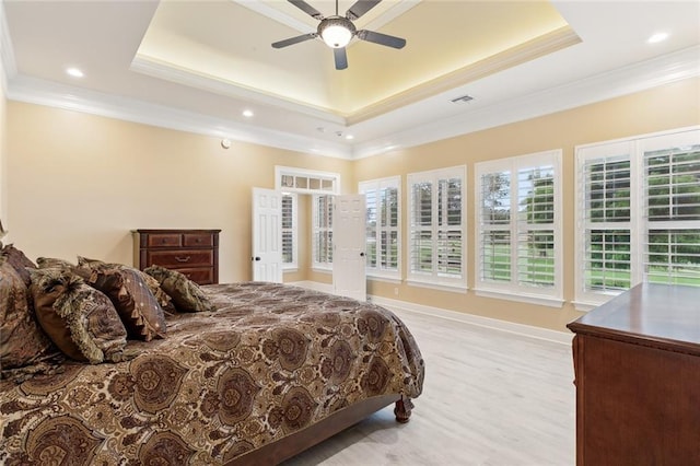 bedroom featuring ceiling fan, ornamental molding, a raised ceiling, and light hardwood / wood-style flooring