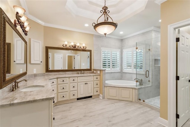 bathroom with plus walk in shower, hardwood / wood-style flooring, vanity, a tray ceiling, and crown molding