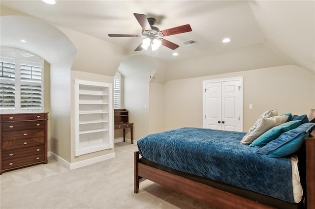 bedroom featuring ceiling fan, light colored carpet, lofted ceiling, and a closet