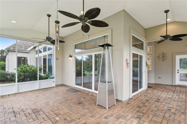 unfurnished sunroom featuring ceiling fan and vaulted ceiling