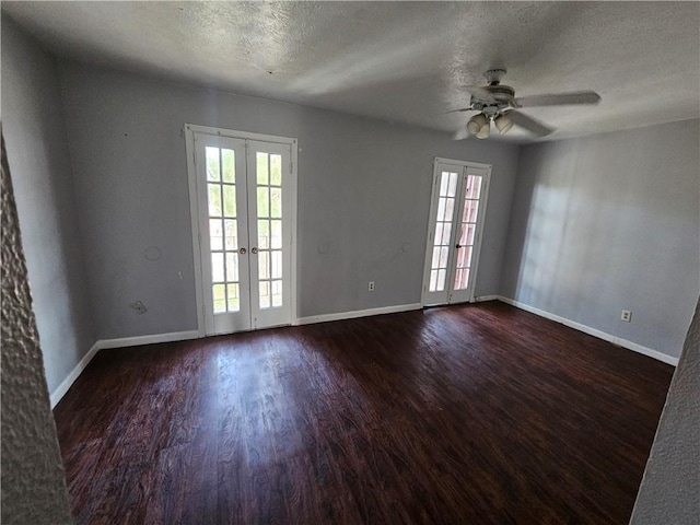 spare room with ceiling fan, dark wood-type flooring, french doors, and a textured ceiling