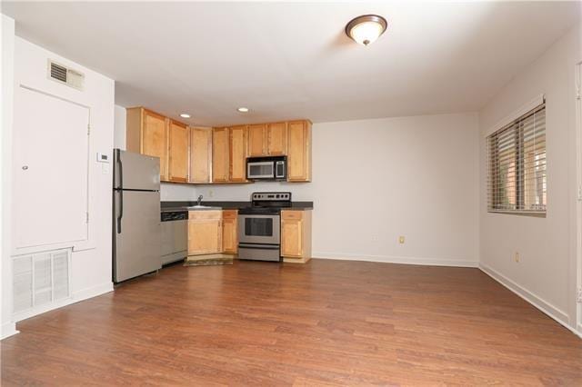 kitchen with hardwood / wood-style flooring and appliances with stainless steel finishes