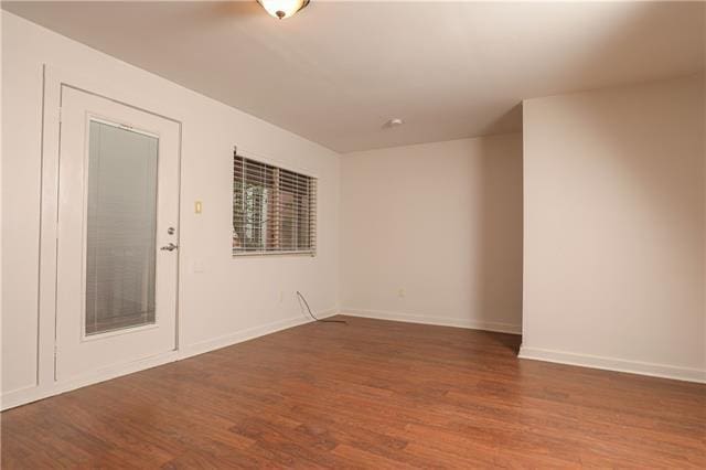 unfurnished room with wood-type flooring