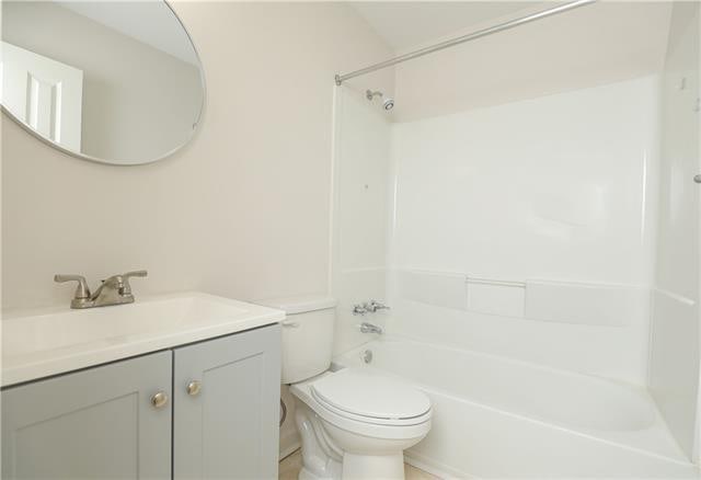 full bathroom with washtub / shower combination, vanity, and toilet