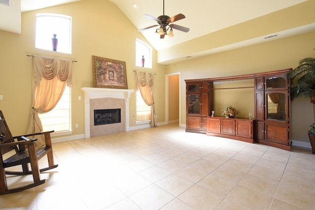 living room featuring a wealth of natural light, high vaulted ceiling, a premium fireplace, and light tile patterned flooring