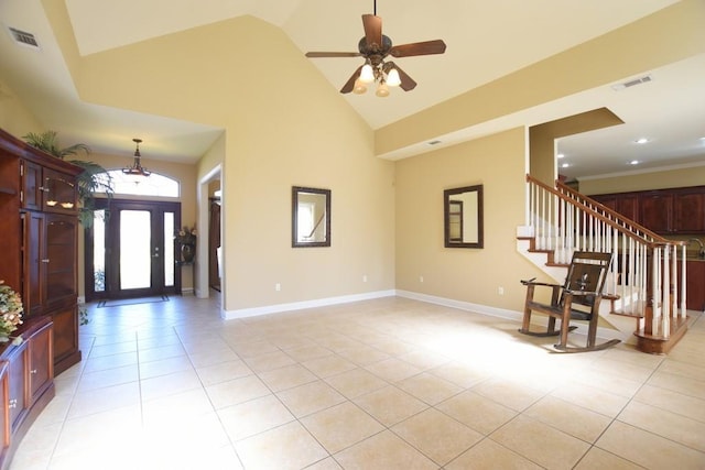 tiled foyer entrance with ceiling fan and high vaulted ceiling